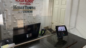 Un comptoir d’accueil équipé d’un ordinateur, d’un terminal de paiement et d’une enseigne Red Roof Inn & Suites.
