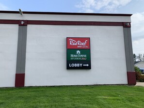 A sign for Red Roof Inn & Suites, Home Towne Studios, and a lobby direction. - HomeTowne Studios by Red Roof Battle Creek (Battle Creek)