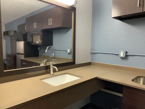 Een moderne badkamer met een wastafel, spiegel en kastjes.