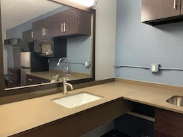 A modern bathroom with a sink, mirror, and cabinets.