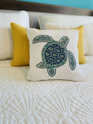 A bed with a quilted pattern and a pillow with a turtle design. - Cozy and Peaceful place-Rio Grande-El Yunque Rainforest  (Río Grande)