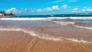 Ein Strand mit klarem Himmel und Wellen.