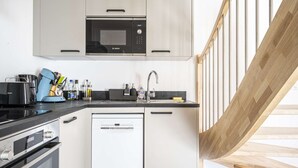 A modern kitchen with a Bosch microwave, a dishwasher, and a coffee maker. - Apartment Comfortable in the centre of Pau: parking, AC... (Pau)