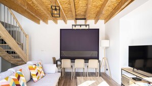 A modern living room with a sofa, chairs, a TV, and a desk with a computer. - Apartment Comfortable in the centre of Pau: parking, AC... (Pau)
