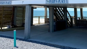A multi-story building with a beach view, featuring a sign that reads "Perry's Place 6".