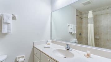 A bathroom with a white sink, mirror, and shower curtain.