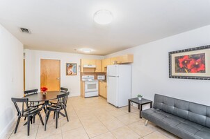 A compact living space with a dining area, kitchenette, and a sofa.