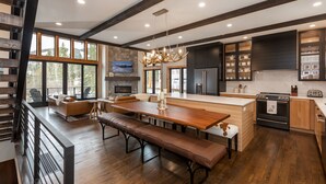 Una cocina moderna con una isla grande, suelo de madera y chimenea de piedra.
