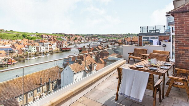 Un balcon avec vue sur une rivière et la ville.
