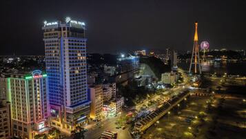 A high-rise hotel with illuminated signage, a prominent tower, and a busy street with vehicles.