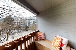 A wooden bench with two patterned cushions against a wall with horizontal siding. - Marketplace Lodge - Whistler Premier (Whistler)