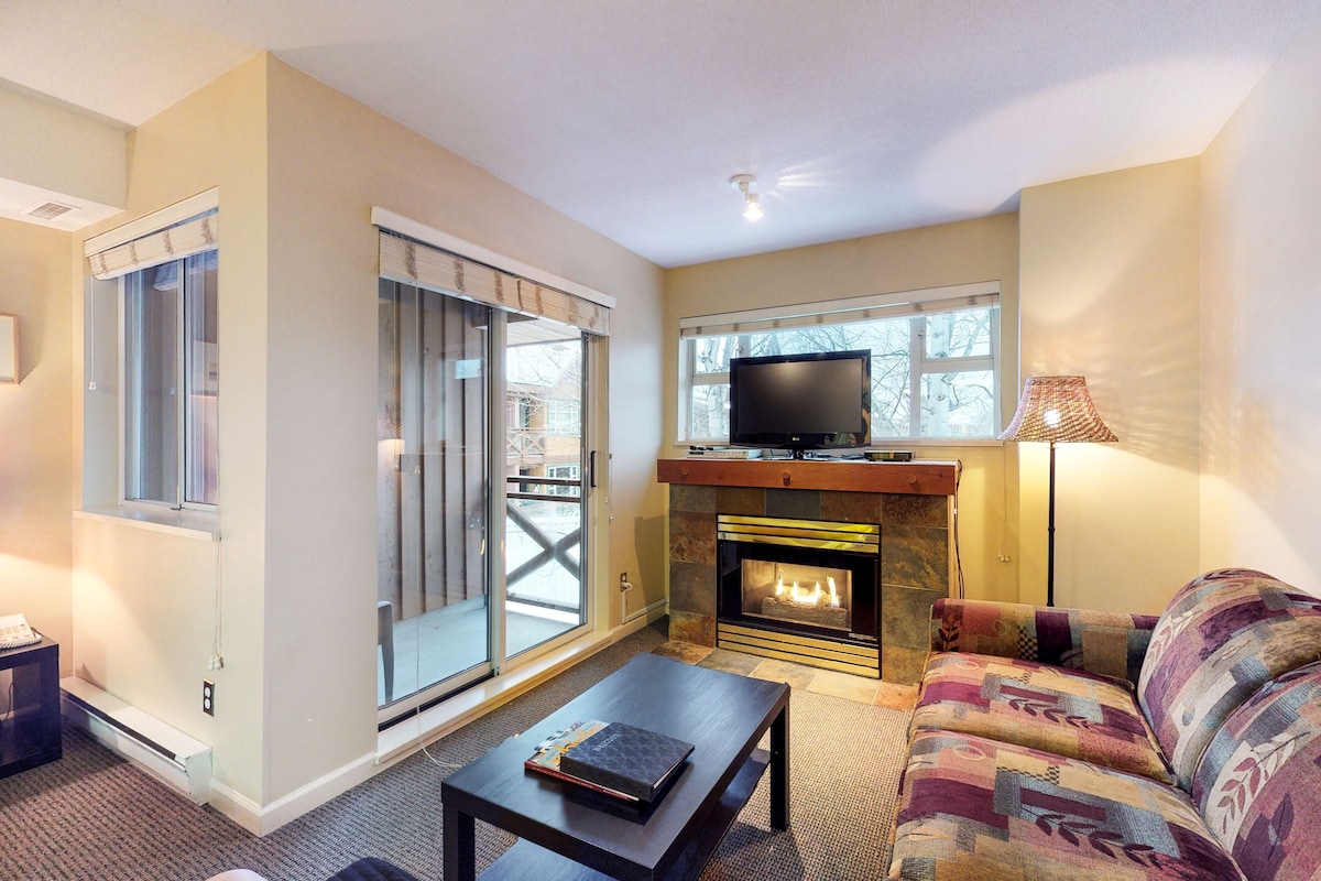A living room with a fireplace, a television, and a sofa.