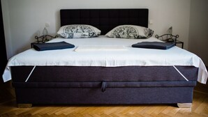 A large bed with a dark headboard, white bedding, and two matching pillows.