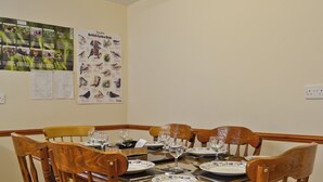 A dining area with a wooden table set for four, surrounded by wooden chairs. - 3 bedroom accommodation in Llanfair Caereinion, near Welshpool (Llanfair Caereinion, near Welshpool)