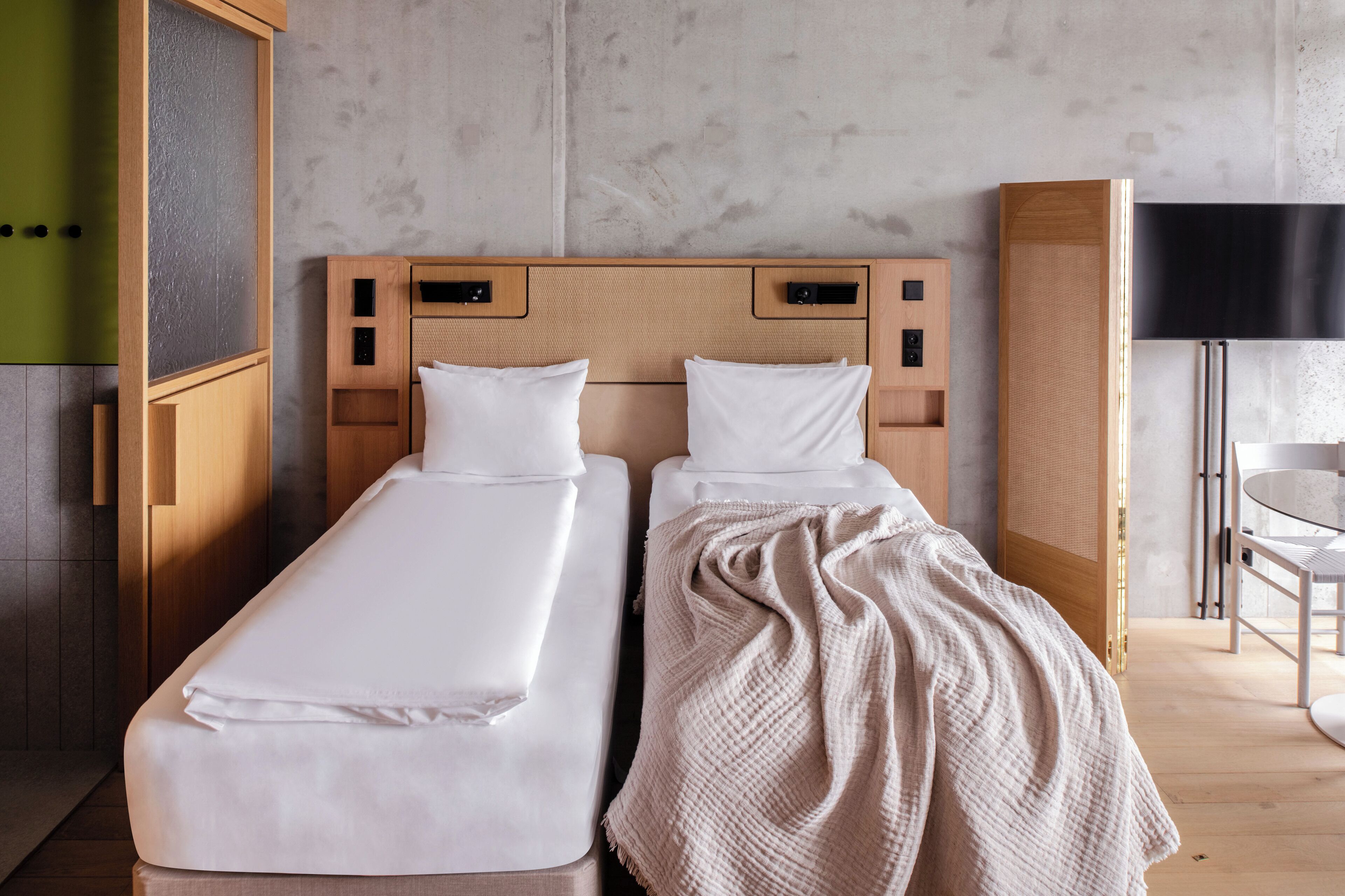 A double bed with a wooden headboard, a bedside table, and a TV.