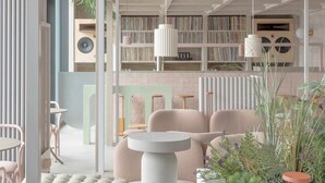 A modern interior with a seating area, bookshelves, and a plant arrangement. - Locke at East Side Gallery (Berlin)