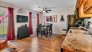 A spacious kitchen with a granite countertop, wooden cabinets, and a built-in oven. - Freshly Remodeled Condo - Fall Creek Resort (Branson)