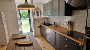 A modern kitchen with grey cabinets, a wooden countertop, and a built-in oven. - 3 Bedroom Private vacation home in PINSAC (PINSAC)