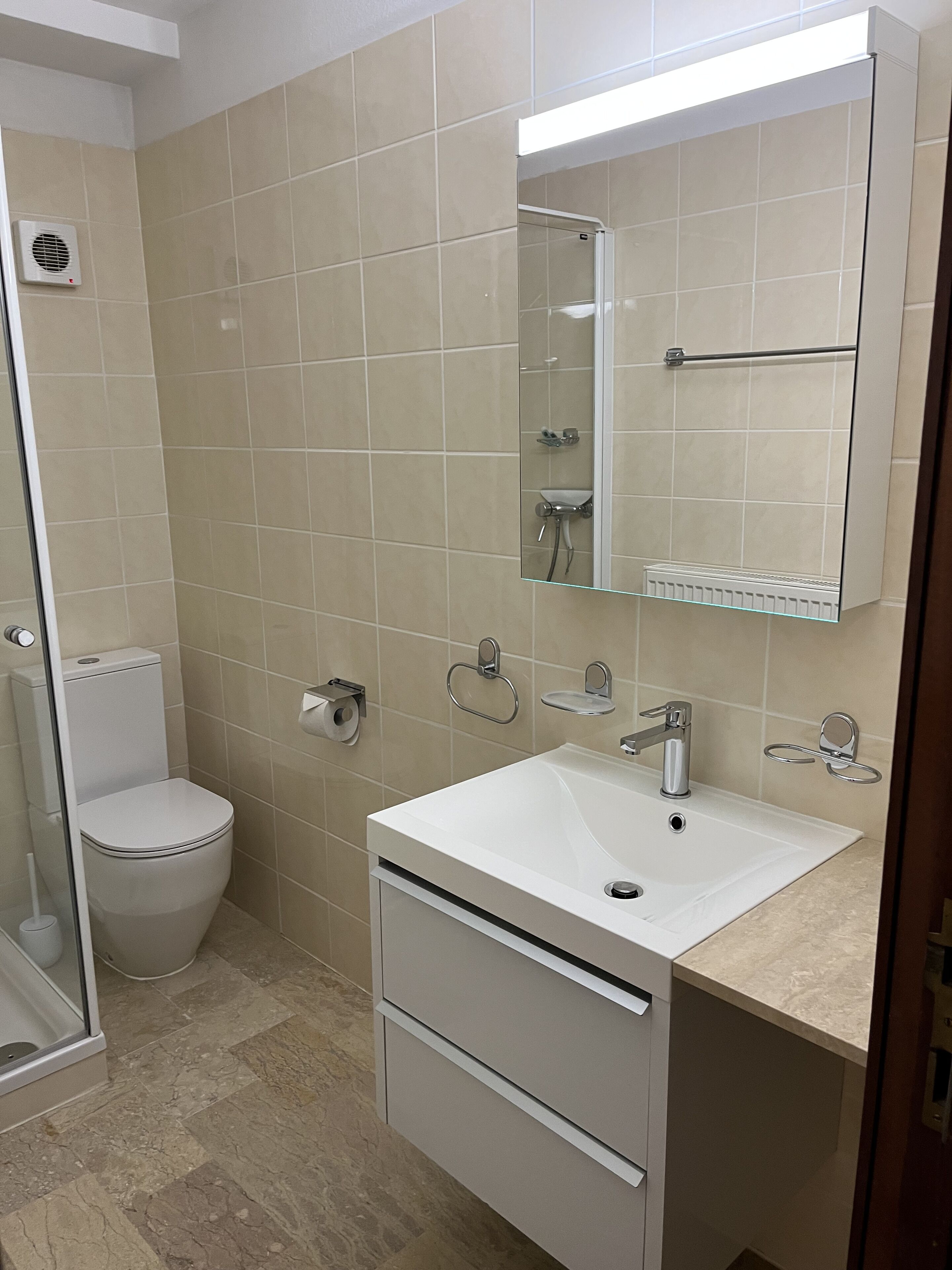 Ein Badezimmer mit Toilette, Waschbecken und Spiegel.