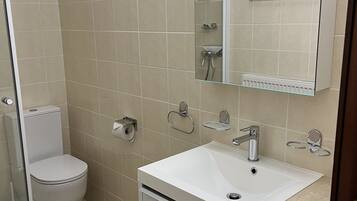 Ein Badezimmer mit Toilette, Waschbecken und Spiegel.