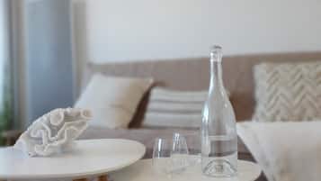 A minimalist living room with a white sofa, a round coffee table, and a decorative white object on the table.