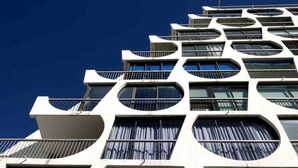 A modern building with a unique architectural design featuring multiple balconies and large windows. - Renovated Boho Studio ☀ Pool | Beach | Queen-size bed (La Grande Motte)