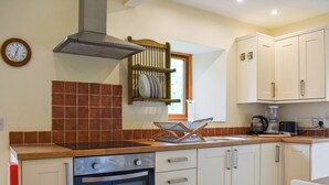 A kitchen with a stove, oven, sink, and cabinets.