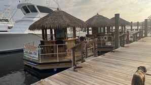 A wooden dock with a tiki bar, a white yacht, and a dog. - Orange Beach, 4 Master Suites, short drive to Beach. Walk to Zekes and SweetCone (Orange Beach)