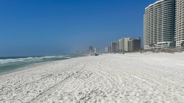 A wide sandy beach with footprints leading towards the ocean. - Orange Beach, 4 Master Suites, short drive to Beach. Walk to Zekes and SweetCone (Orange Beach)