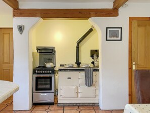 Un angolo cottura compatto con forno, fornelli e un piccolo piano di lavoro.