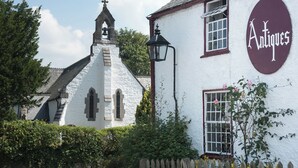 A white building with a bell tower and a sign reading "Antiques". - Dol y Mynydd (The Mountain Meadow)-QU7521 (Abergele)