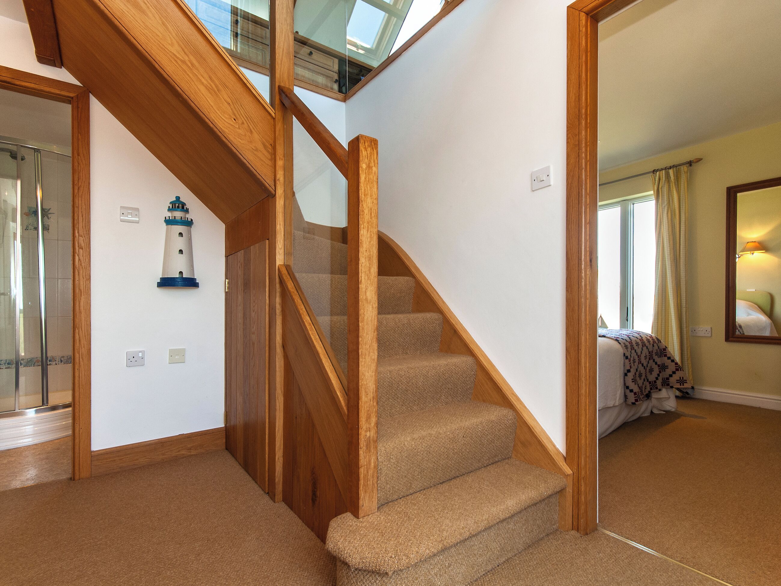 A staircase with wooden railings and carpeted steps leading to a second floor.