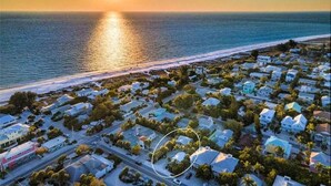 An aerial view of a coastal residential area with houses and a beach. - Beach Don't Kill My Vibe by Beach Boutique Rentals (Anna Maria)