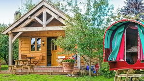 A wooden cabin with a porch, a covered seating area, and a small garden. - 1 bedroom accommodation in Malpas (Malpas)