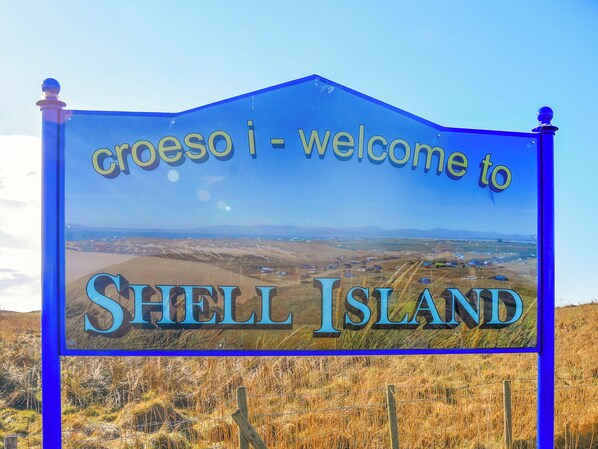 Segnaletica di benvenuto per Shell Island con una vista panoramica del paesaggio.