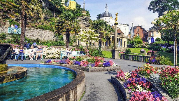 A garden with a fountain, benches, and a variety of flowers. - 2 bedroom accommodation in Portmeirion (Portmeirion)