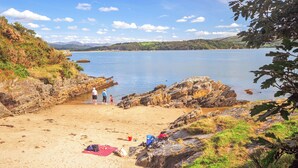 A beach with rocky terrain, a sandy area, and a calm body of water. - 2 bedroom accommodation in Portmeirion (Portmeirion)
