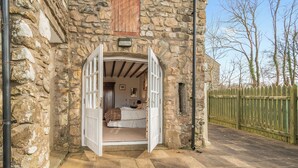 A stone building with a bedroom visible through an open doorway. - 3 bedroom accommodation in Cerbid (Cerbid)