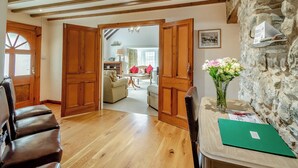 A room with wooden floors, a stone wall, and a wooden door leading to another room. - 3 bedroom accommodation in Cerbid (Cerbid)
