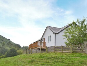 A house with a white exterior, a wooden deck, and a brick foundation. - 3 bedroom accommodation in Llanfair Caereinion, near Welshpool (Llanfair Caereinion, near Welshpool)