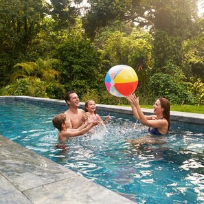 A swimming pool with clear water, surrounded by lush greenery. - Apartamentos y Villas D Angelo (Manzanillo)