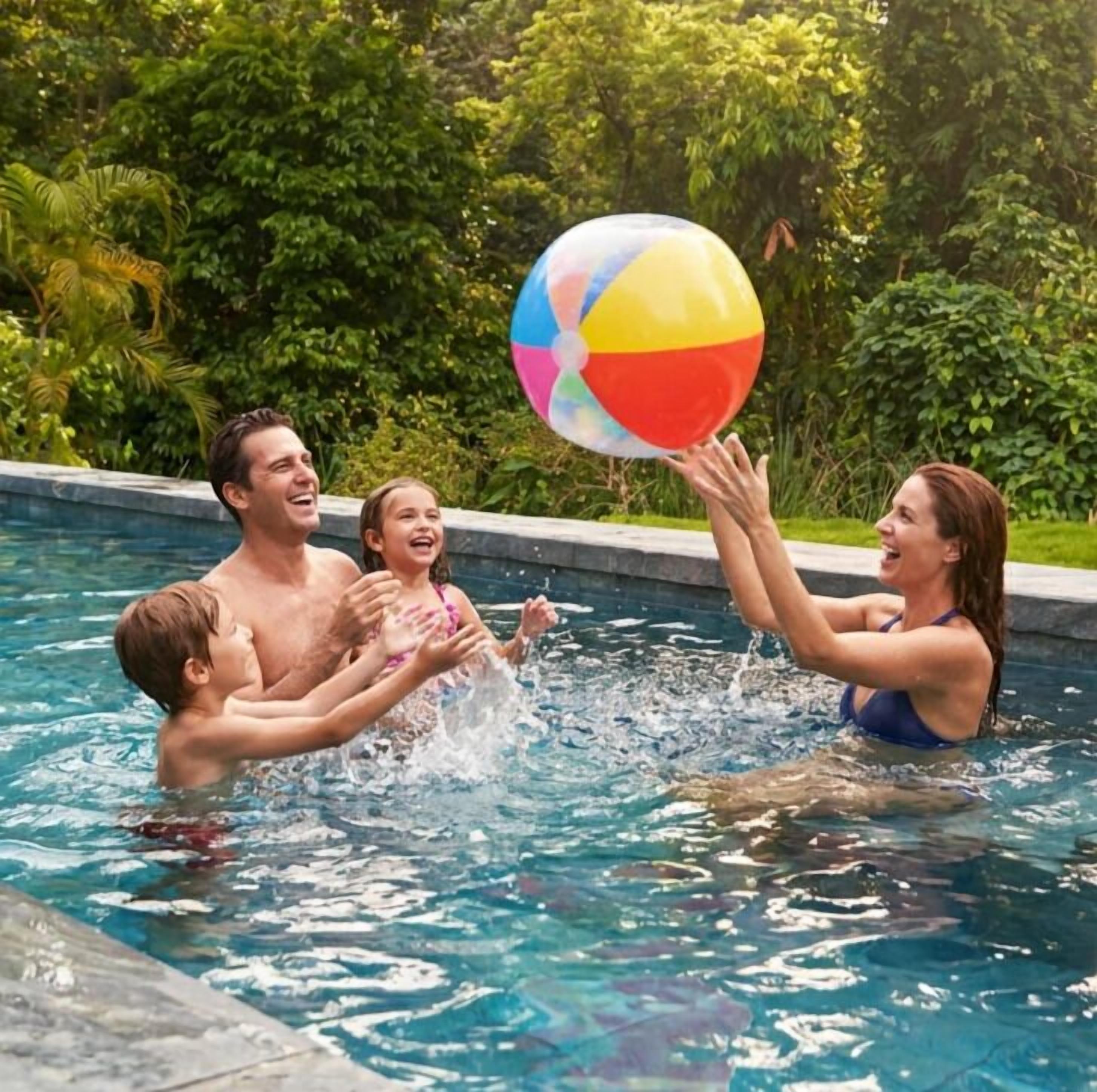 Eine Familie spielt mit einem Strandball in einem von Grünanlagen umgebenen Schwimmbecken.