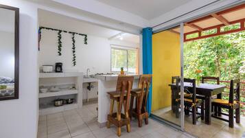 A kitchen with white cabinets, a coffee maker, and a small island with stools.