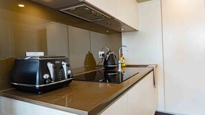 A compact kitchen with a toaster, kettle, and a small countertop.
