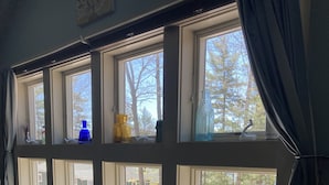 A room with a large window, a table, and two chairs. - Studio Apartment on lake near Camden, Maine. (Lincolnville)