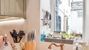 A kitchen with a copper faucet, a coffee maker, and various utensils. - 1 bedroom accommodation in Keswick (Keswick)