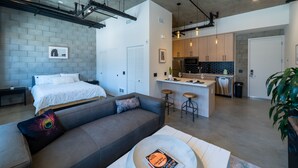Eine moderne Wohnung mit Küchenzeile, Essbereich und Wohnzimmer mit Sofa und Couchtisch.