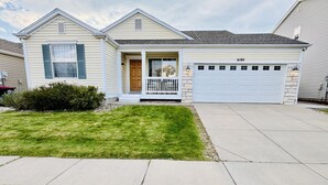 A single-story house with a front porch, a garage, and a well-maintained lawn. - Colorado Springs Home · Hot Tub · Built for Longer Stays (Colorado Springs)