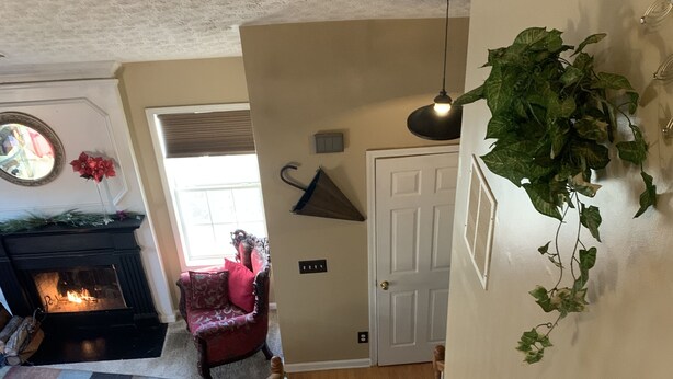Una escalera que sube a un segundo piso, con vista a una sala de estar inferior.