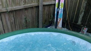 Un jacuzzi con una valla de madera al fondo.